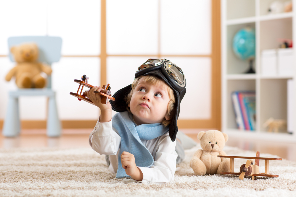 Child boy toddler playing with toy airplane