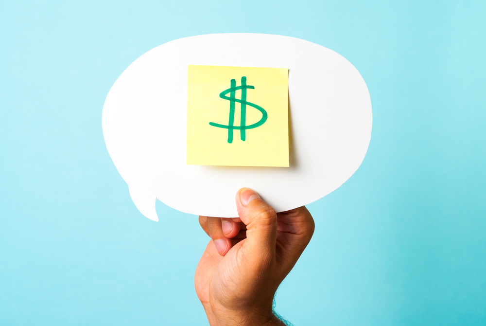 Green dollar money sign symbol on stick-note over speech bubble