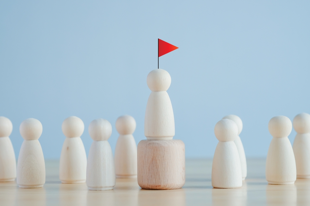 Wooden figure leader with red flag