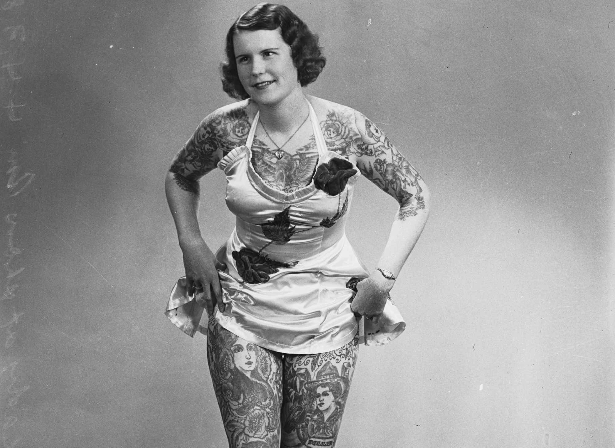 Tattooed lady Betty Broadbent standing in short dress
