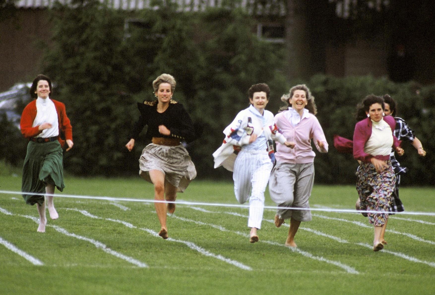 Diana, Princess of Wales, runs barefoot as she takes part in the Mother's race during Prince Harry's school sports day in Richmond on June 11, 1991 in London