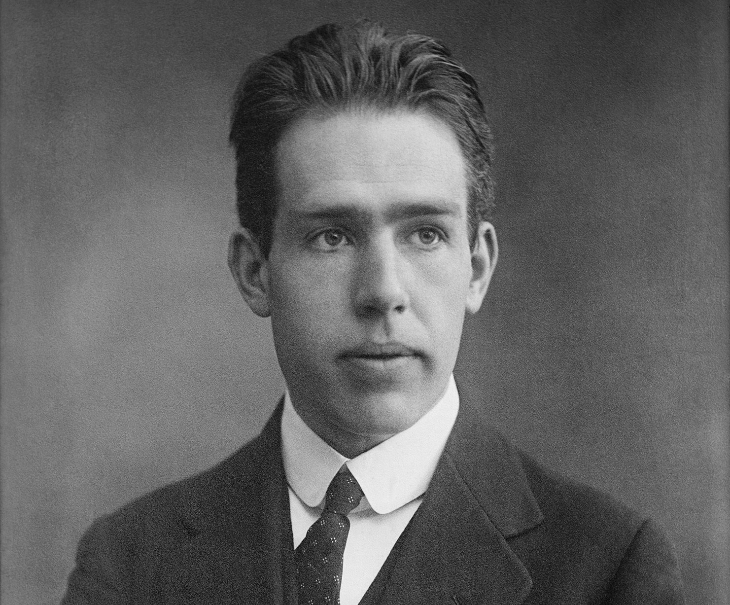 Grayscale Portrait Photo of the physicist Niels Bohr in a dak suit