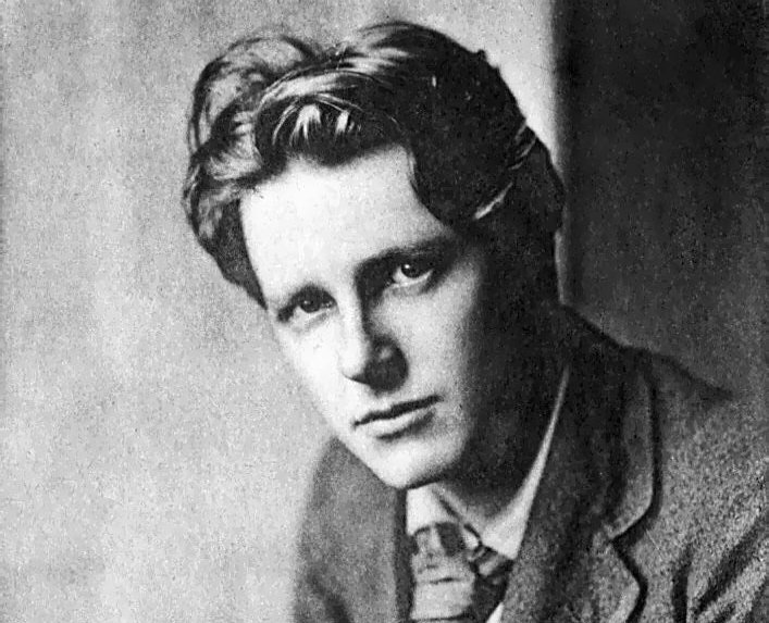 Grayscale Portrait Photo of Rupert Brooke in a dark suit
