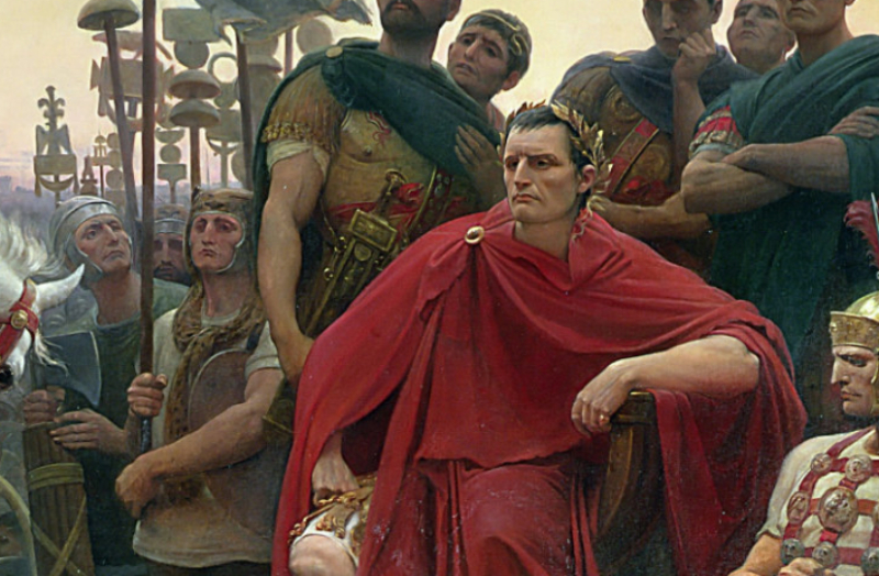 Julius Caesar in red clothes sitting surrounded by soldiers