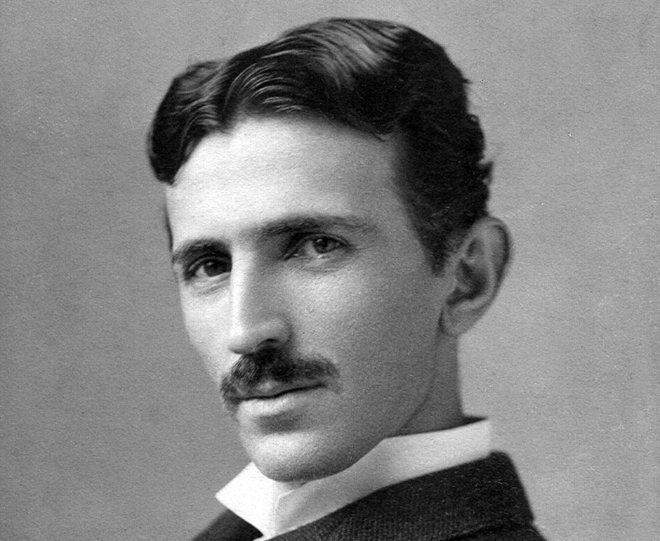 Grayscale Portrait Photo of Nikola Tesla in a dark suit