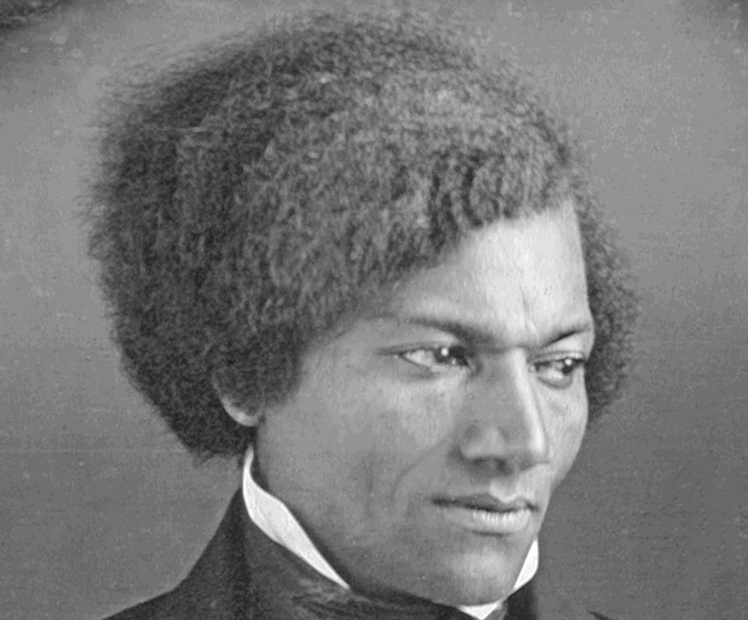 Grayscale Portrait Photo of Frederick Douglass in a dark suit