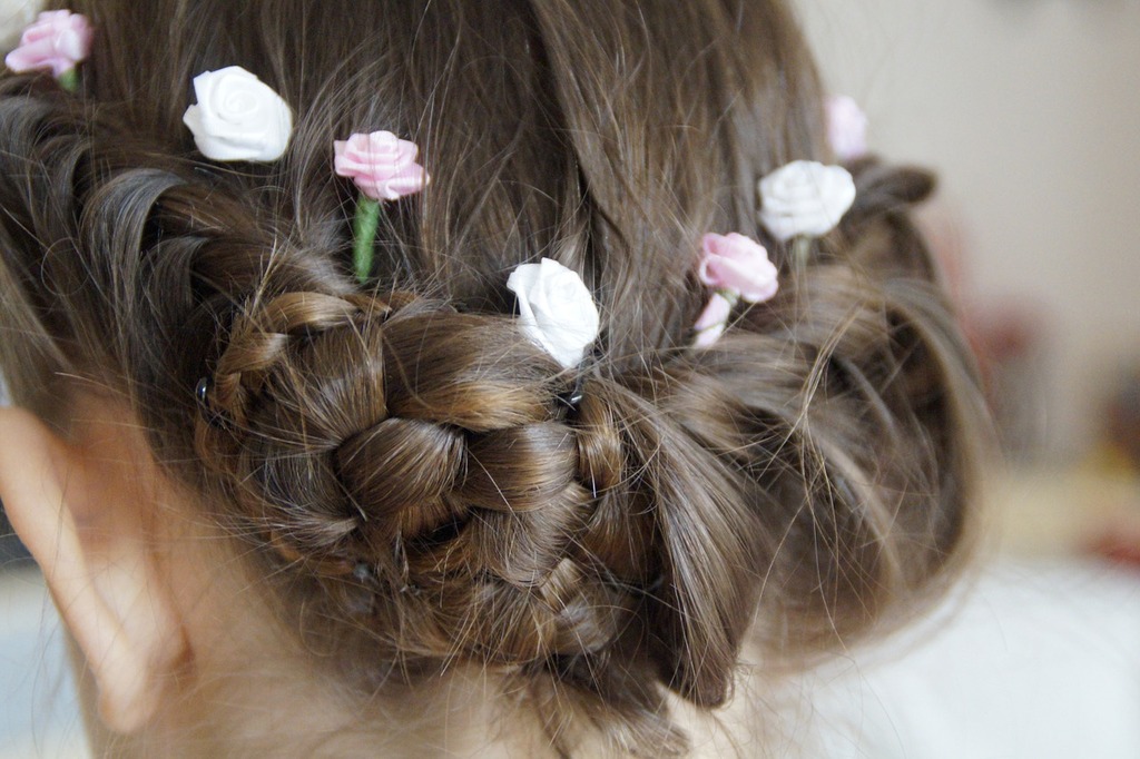 A girl with a braided bun with roses
