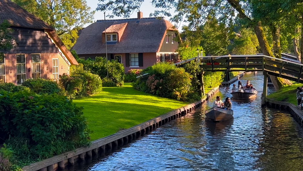 Traditional dutch houses, gardens and water canals and wooden bridges