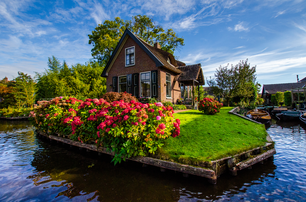 House with beautiful flowers on small island in Giethoorn