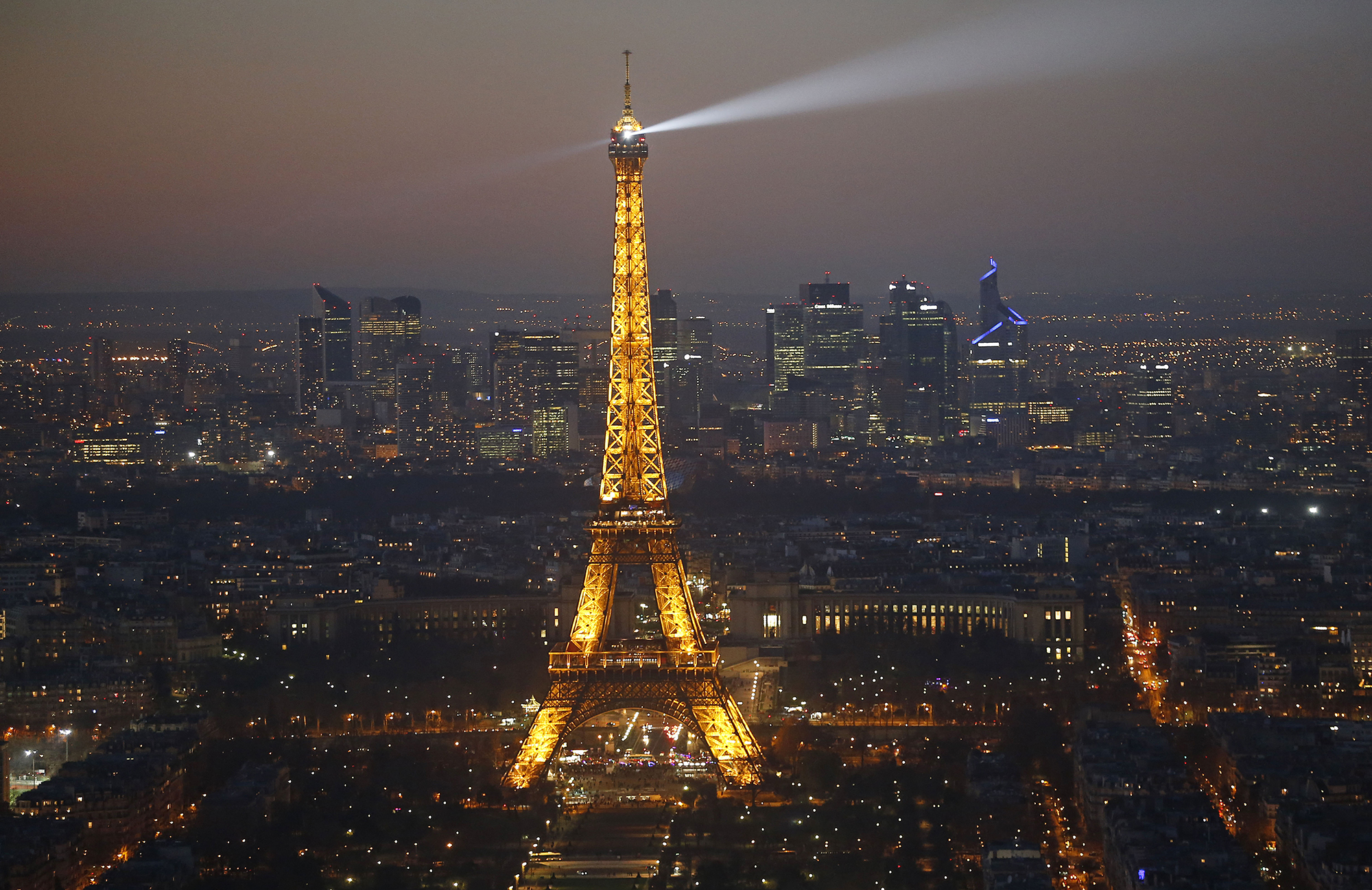 The Eiffel tower and the business district of La Defense are seen by night on December 03, 2016 in Paris, France.
