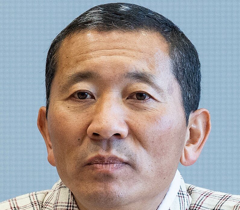 Portrait Photo of Lotay Tshering in white shirt, facing the camera