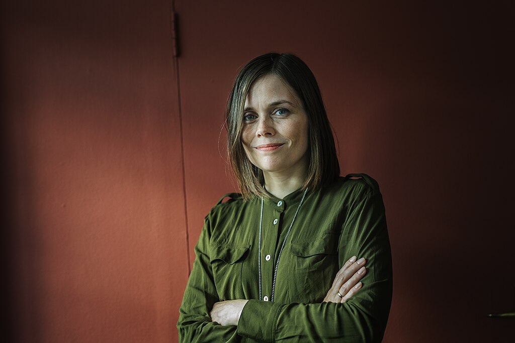 Portrait Photo of Katrín Jakobsdóttir in green outfit with crossed arms