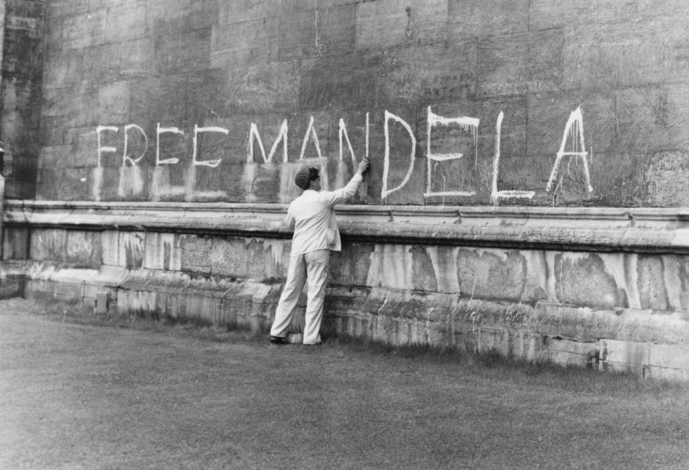 A man washing a 'Free Mandela' slogan