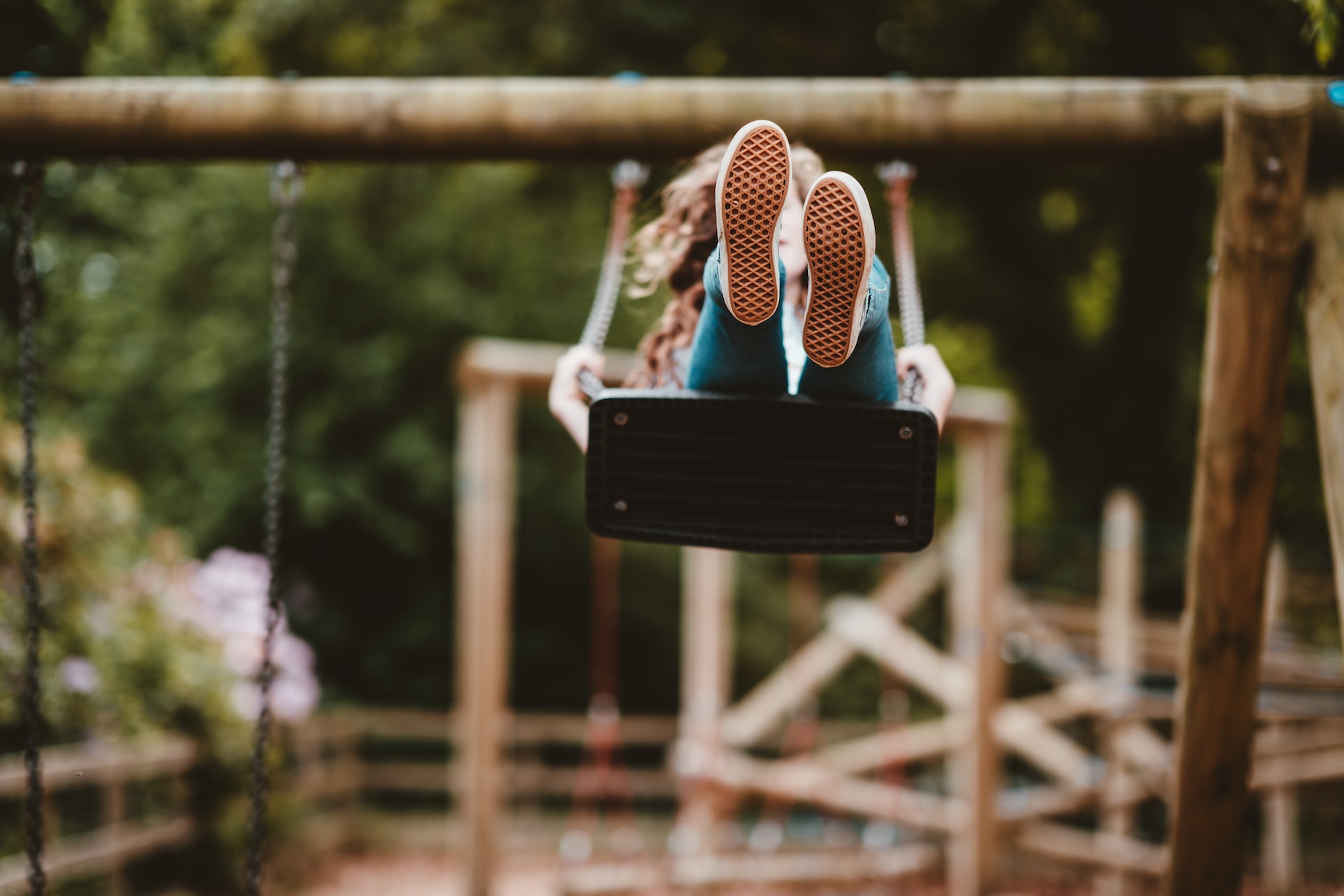Girl playing on a swing at a playground