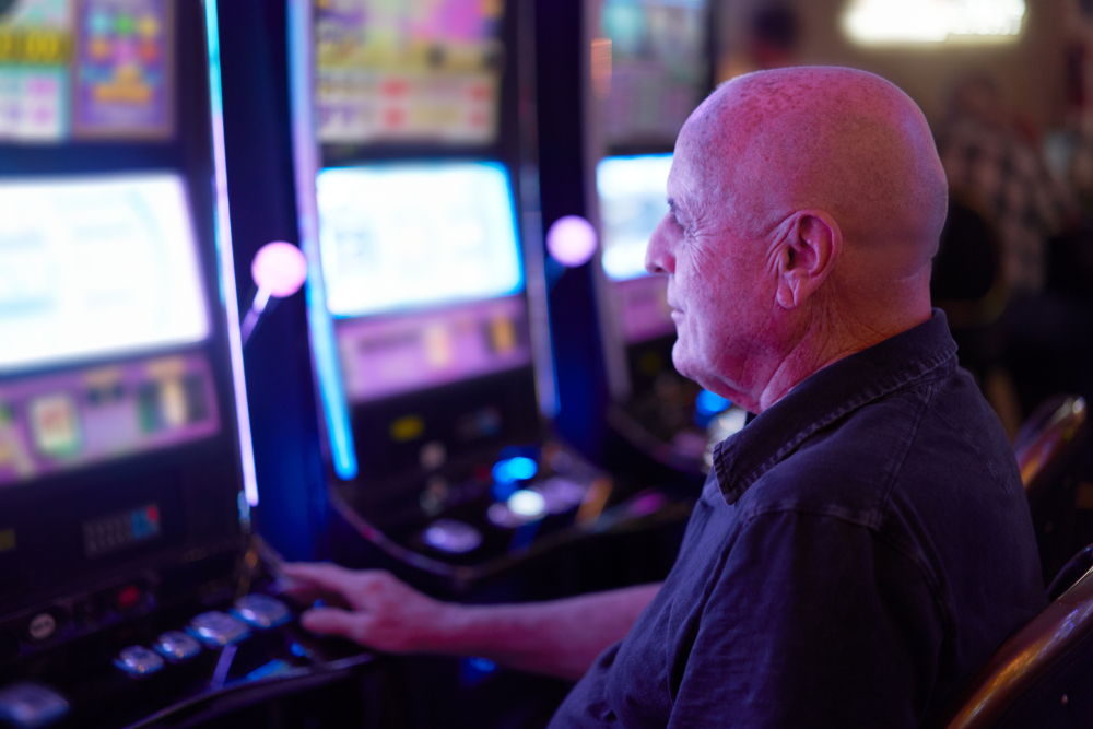 elderly tourist playing slot machines