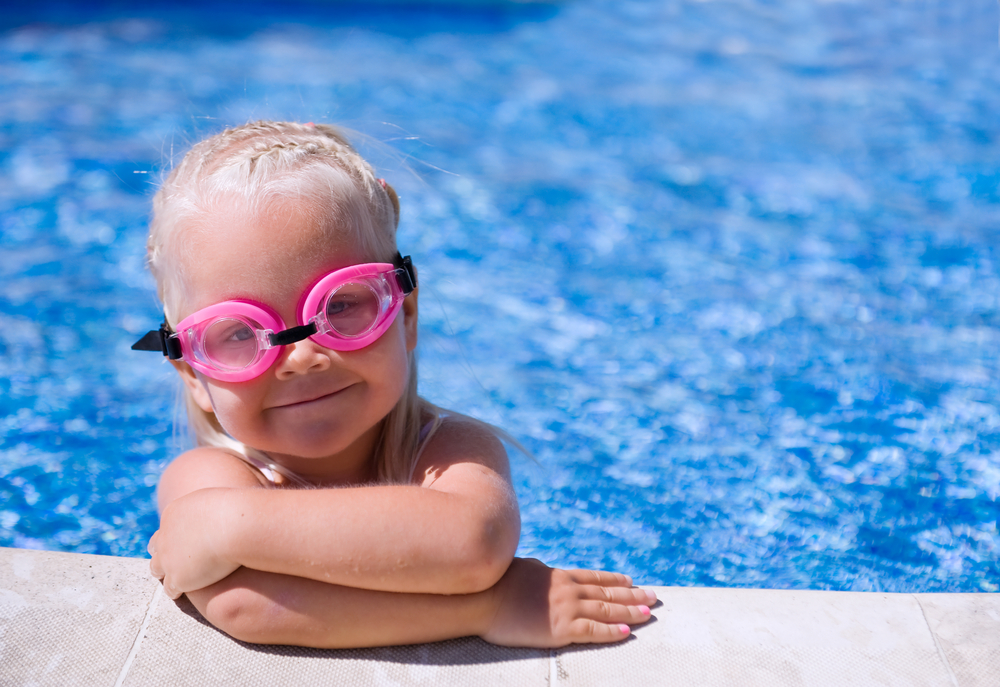 Smiling baby girl wearing swimming glasses