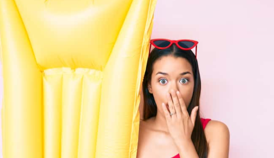 Girl wearing swimsuit and holding summer matress.