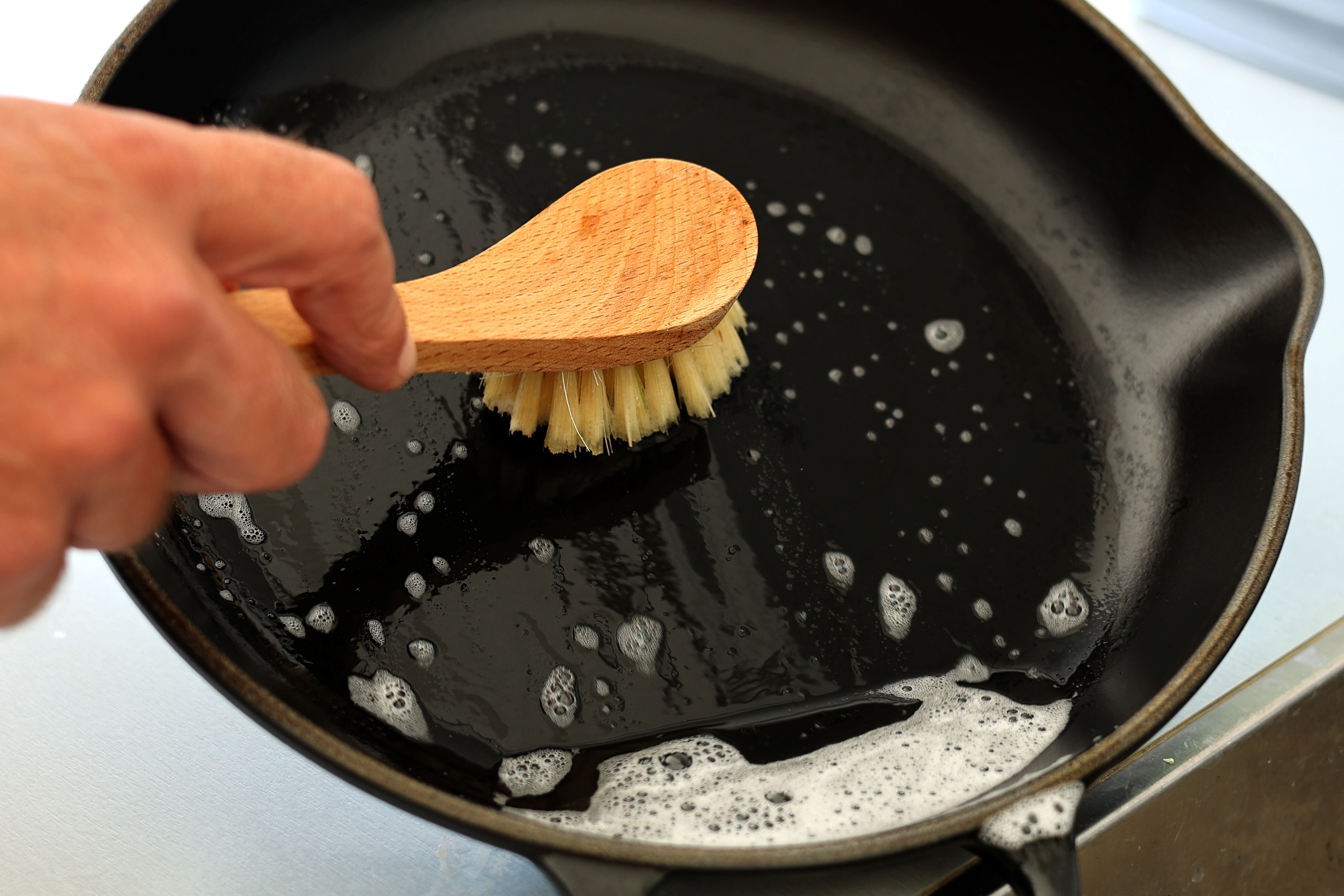 Cleaning a cast iron pan in the sink 
