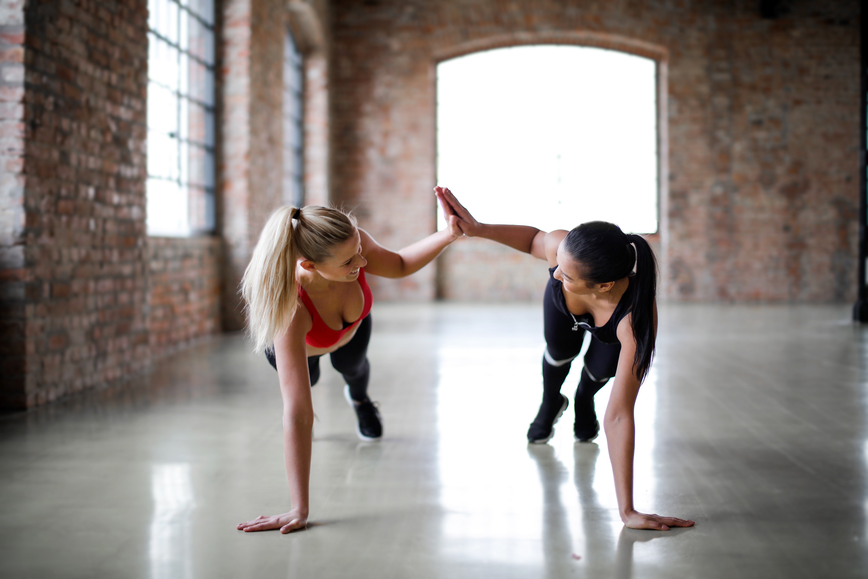 Friends supporting each other doing yoga