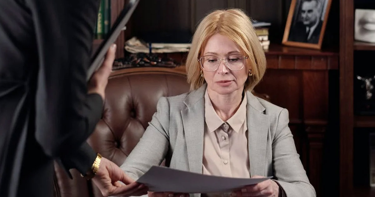 Two businesswomen reviewing documents in a classic office setting.