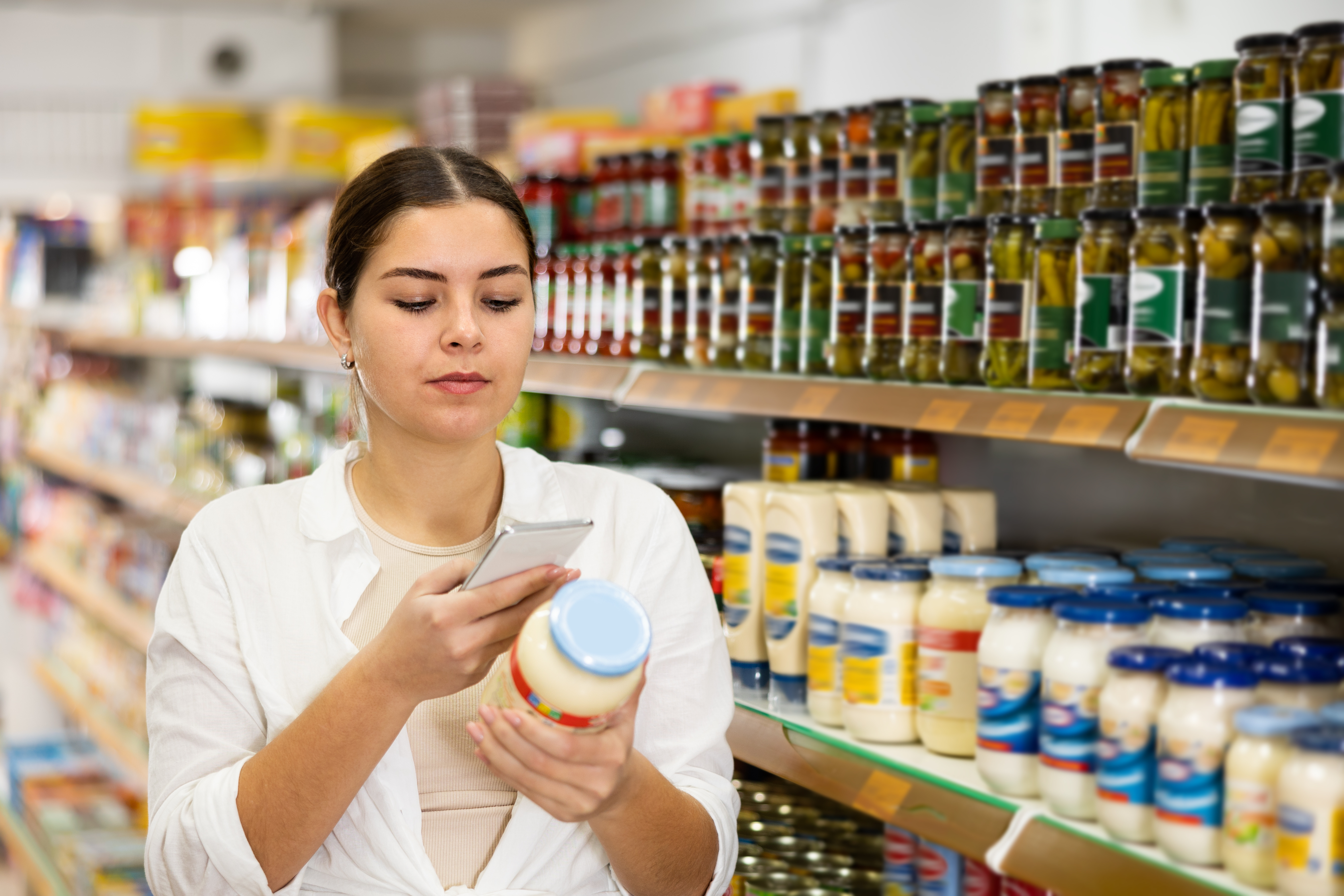 A woman checking her phone while shopping