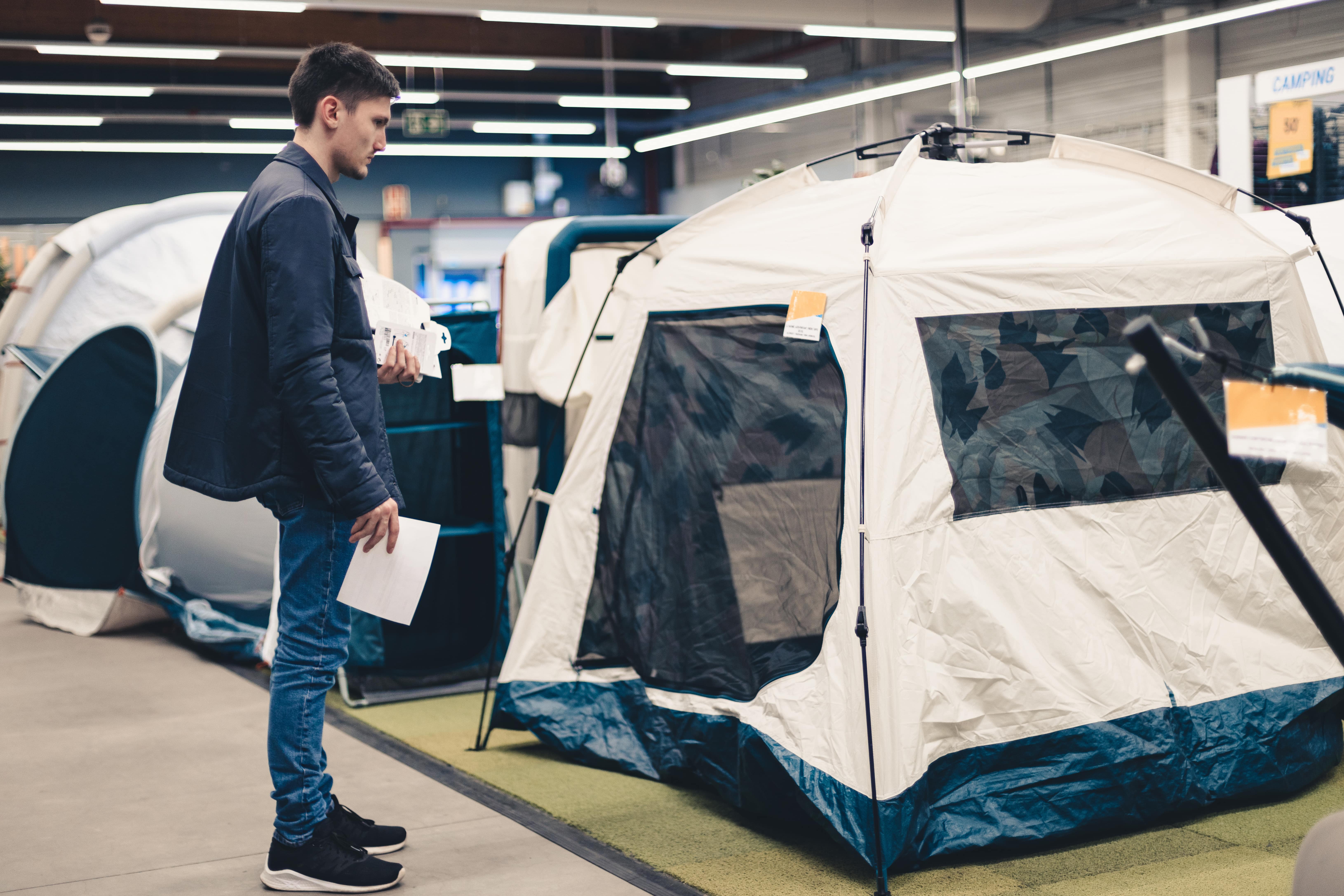 Man carefully choosing a tent to buy