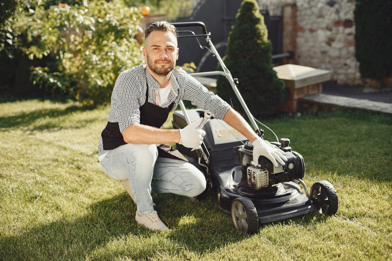Man Sitting beside a Lawn Mower
