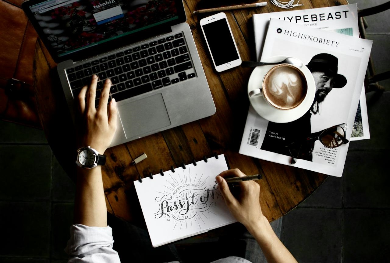Person Sitting Facing Laptop Computer With Sketch Pad