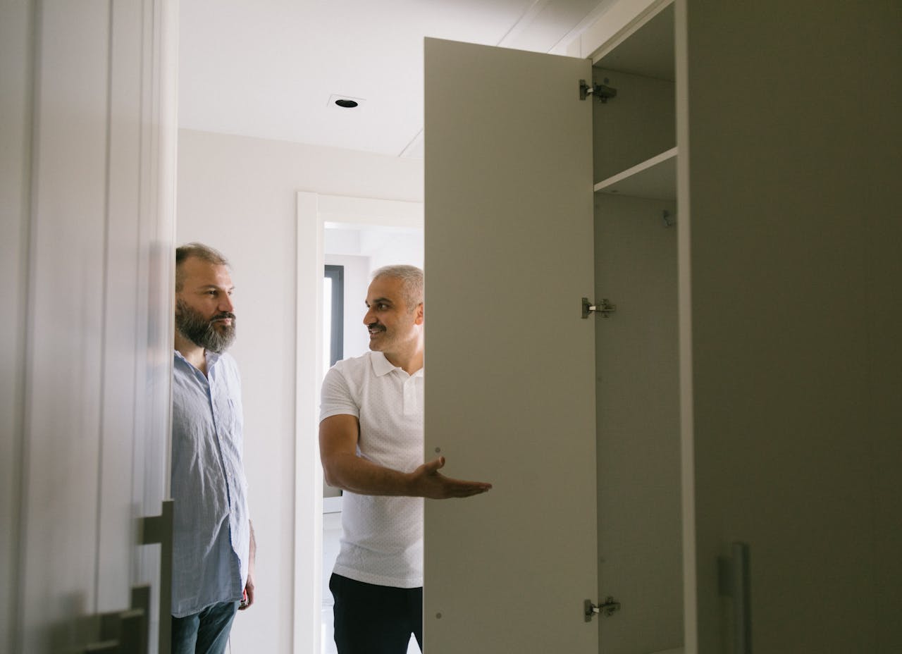 an in White Polo Shirt Showing the Closet to a Man in Gray Shirt