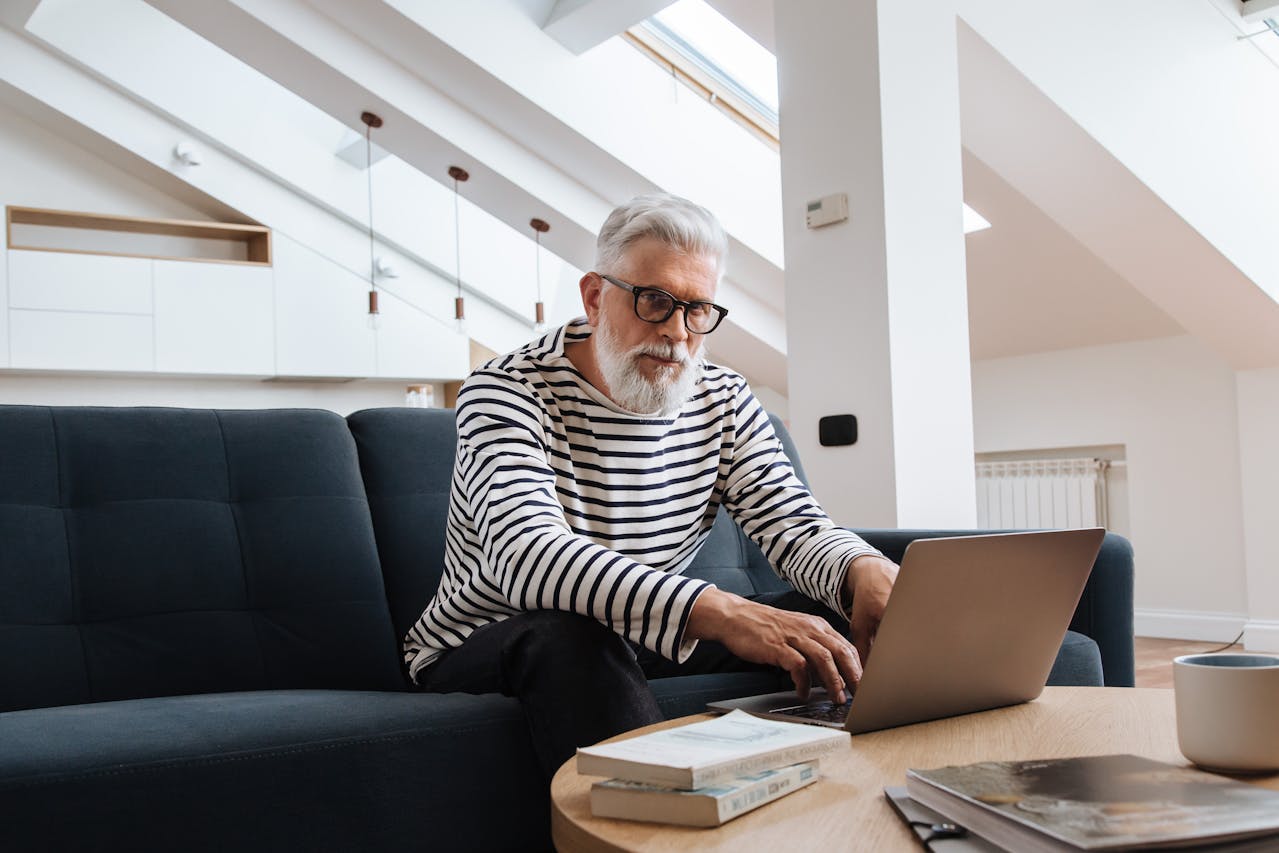 Man Sitting and Working with Laptop on Table