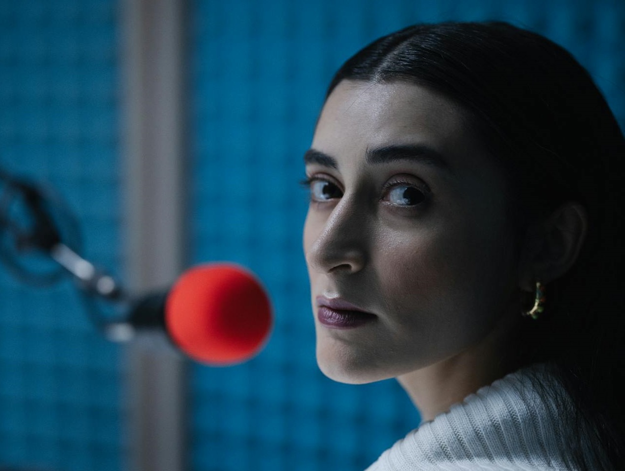 Woman in Front of a Red Mic at studio.