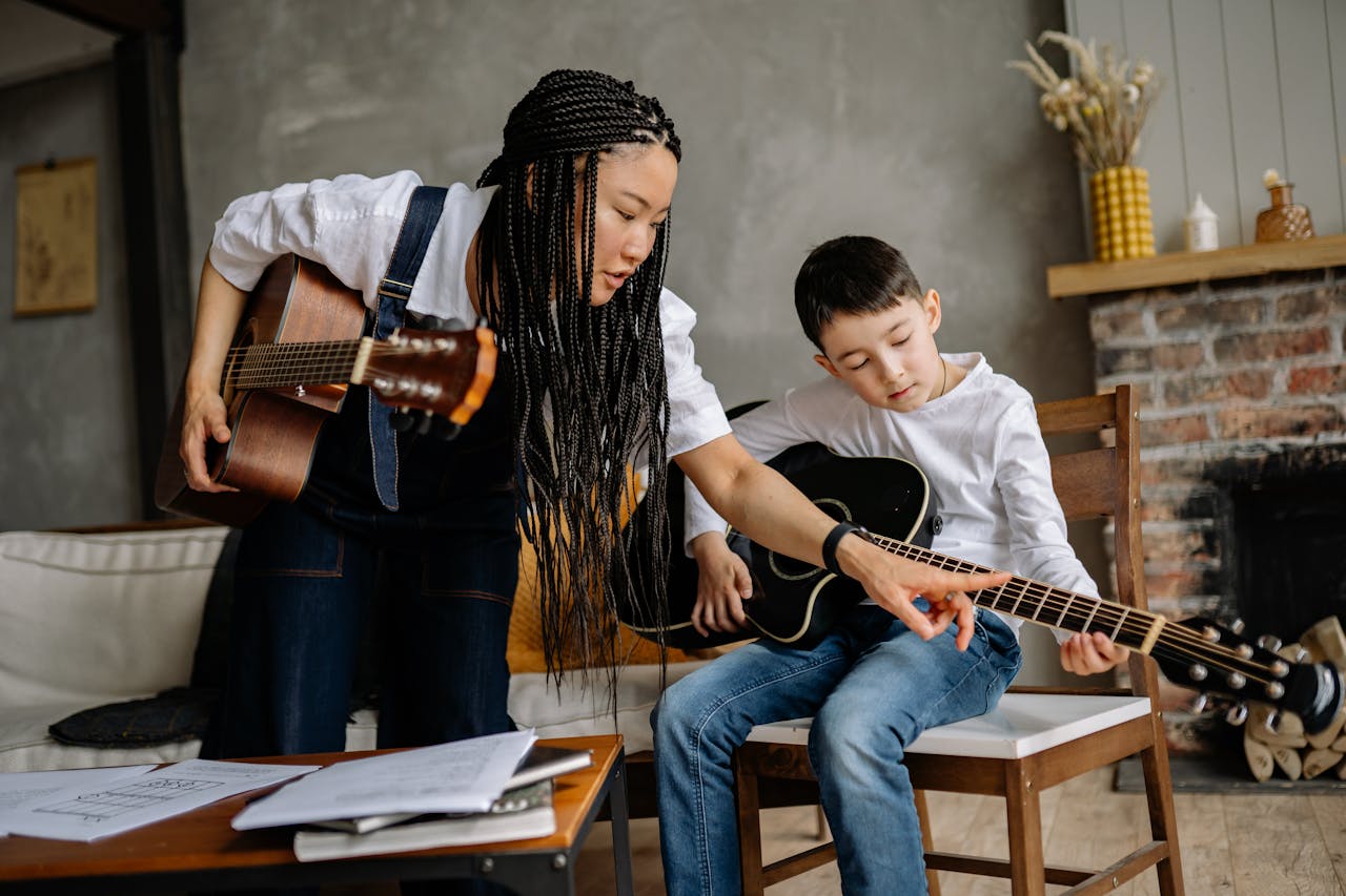 A Music Instructor Teaching a Boy to Play Guitar