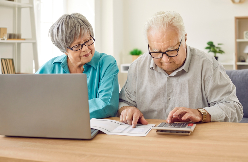 Portrait of elderly couple calculating finances or taxes