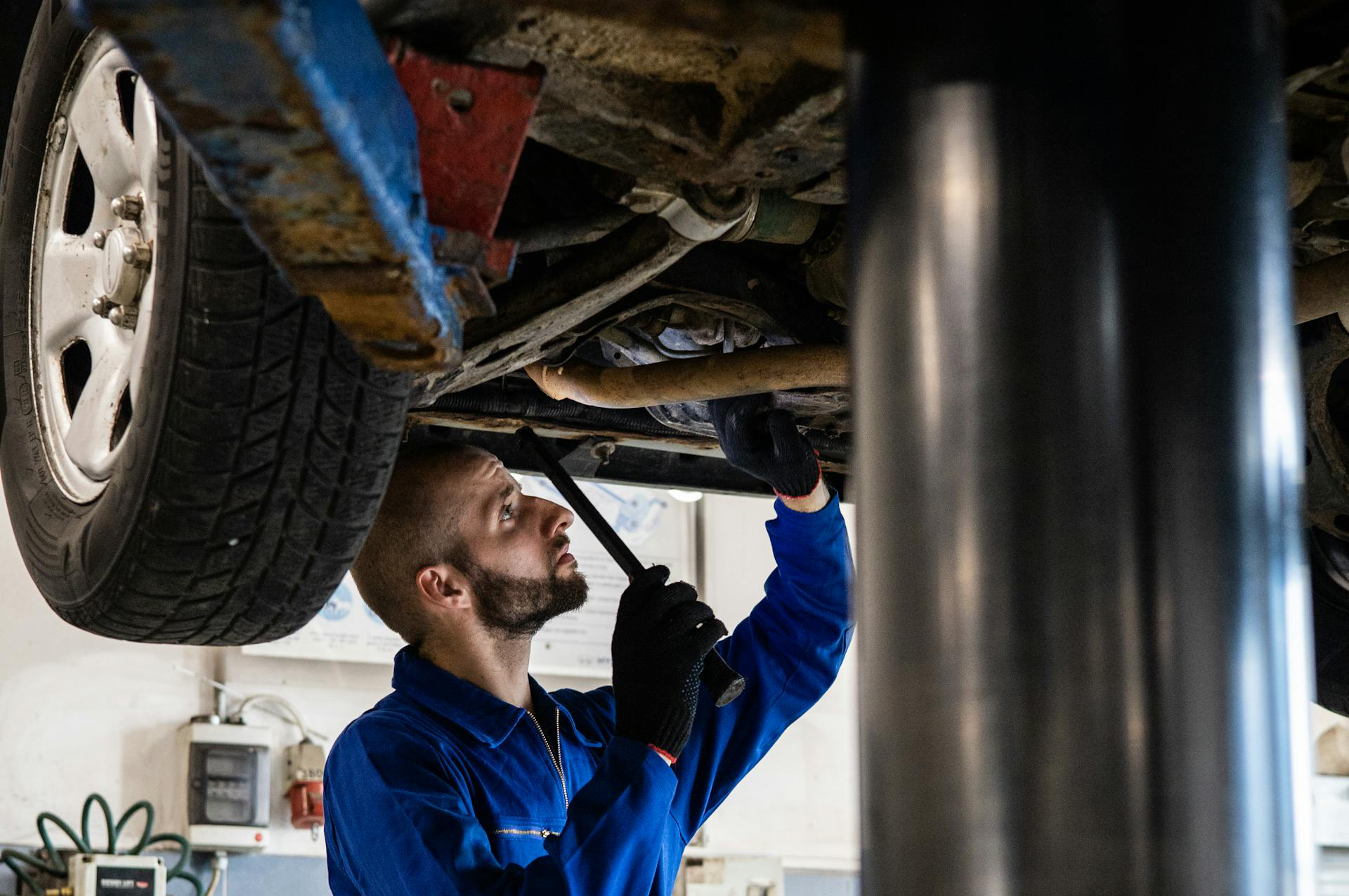 A Mechanic Working Under A Vehicle