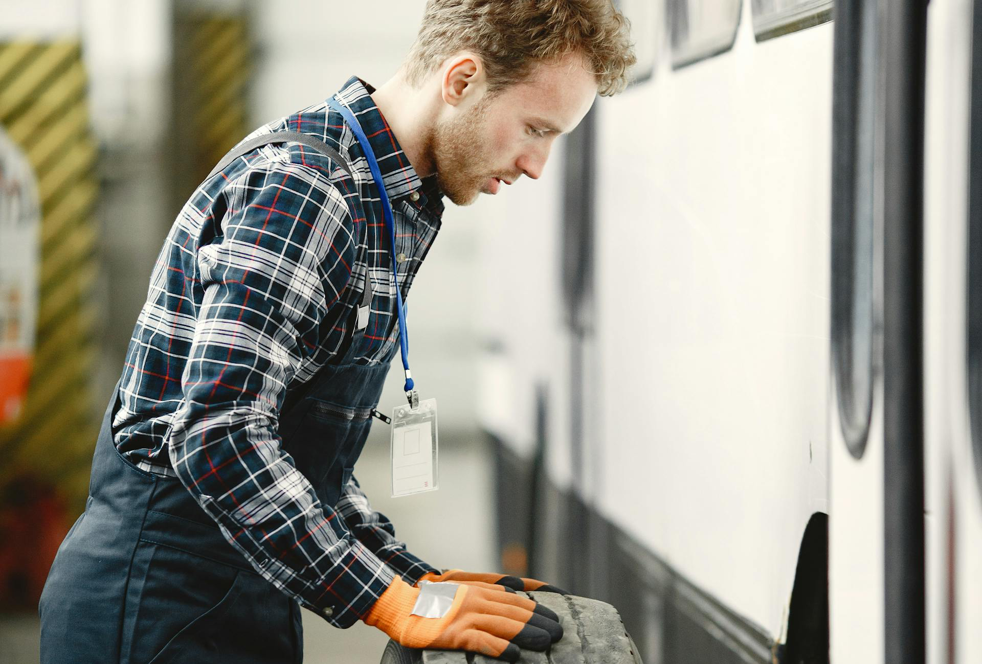 A Bus Mechanic Holding a Tire