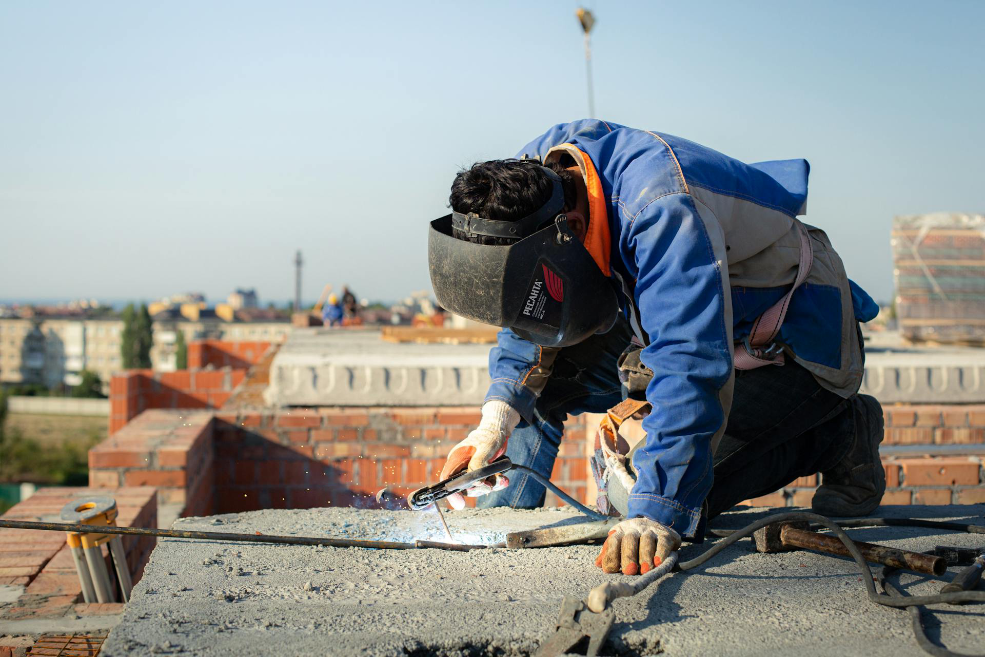 Man Welding Wires on Roof