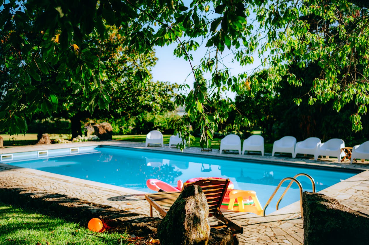 A pool in the middle of a lush green yard