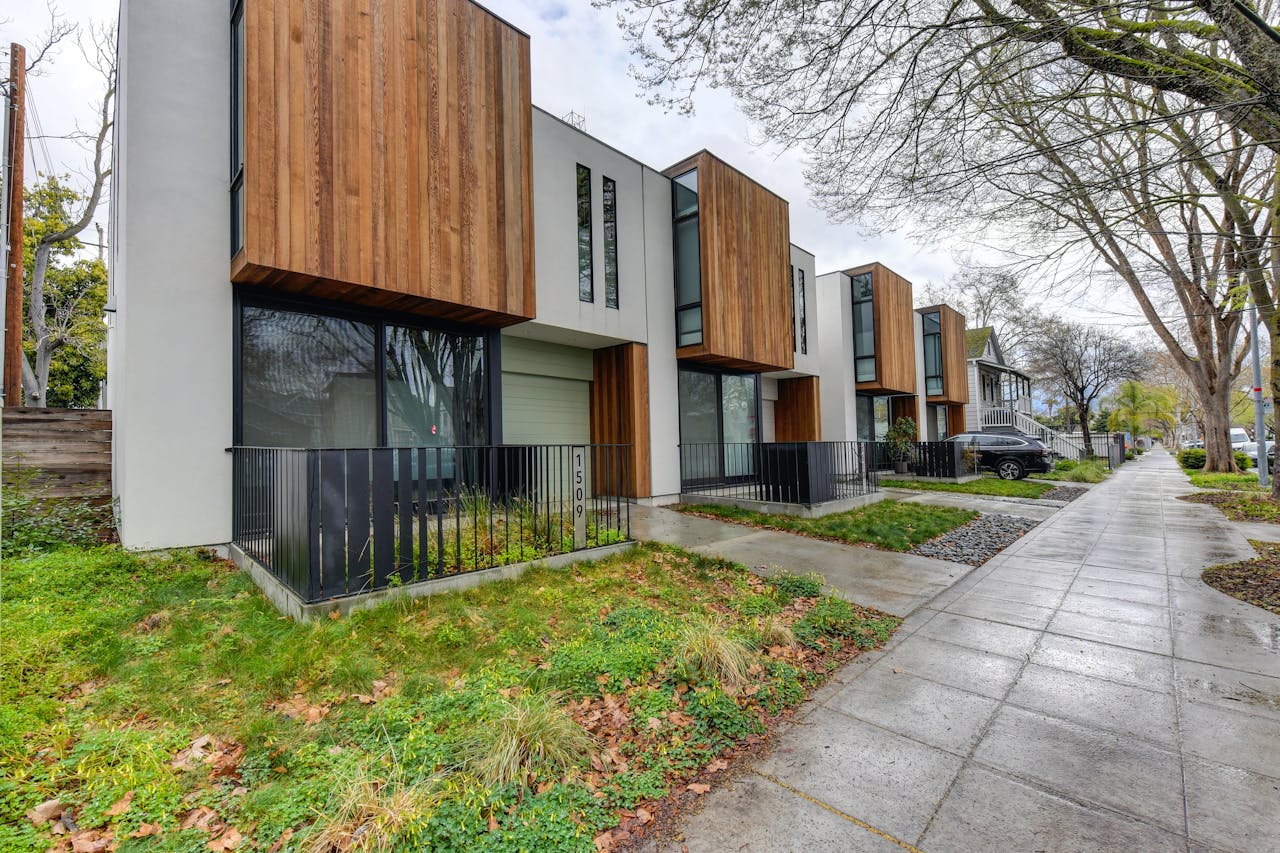 A modern home with wooden siding and a sidewalk