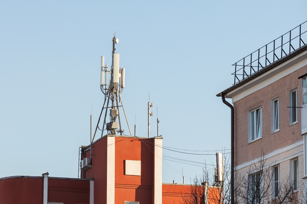 Cell phone towers on the roof of a building near residential buildings
