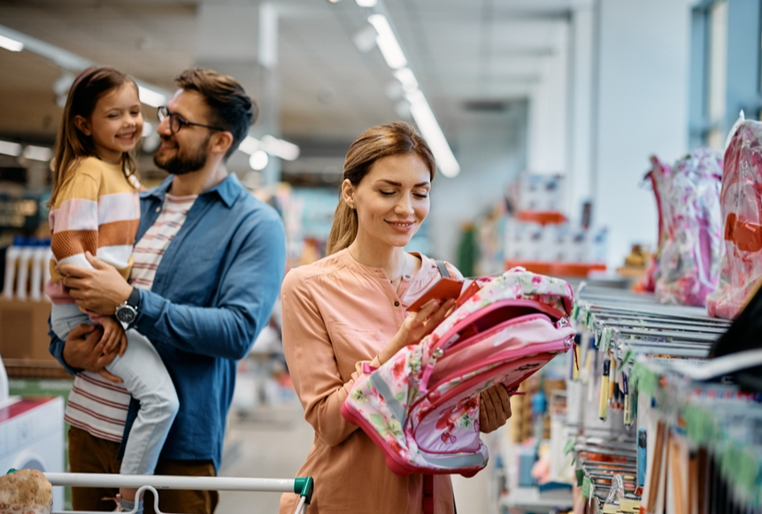 Happy family buying backpack and school supplies in a store