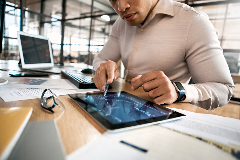 Confident businessman in formalwear pointing at tablet computer
