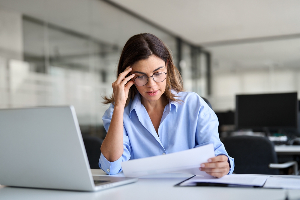 Professional business woman reading news in document at work
