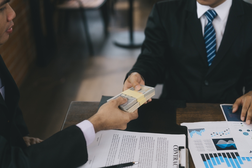 Business partners signing contract to borrow money from investor