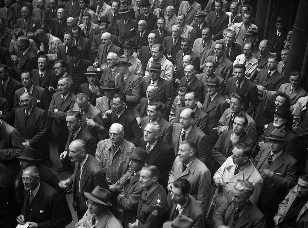Group of people wearing uniforms and suits looking upwards