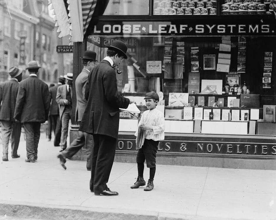 Young boy selling newspapers