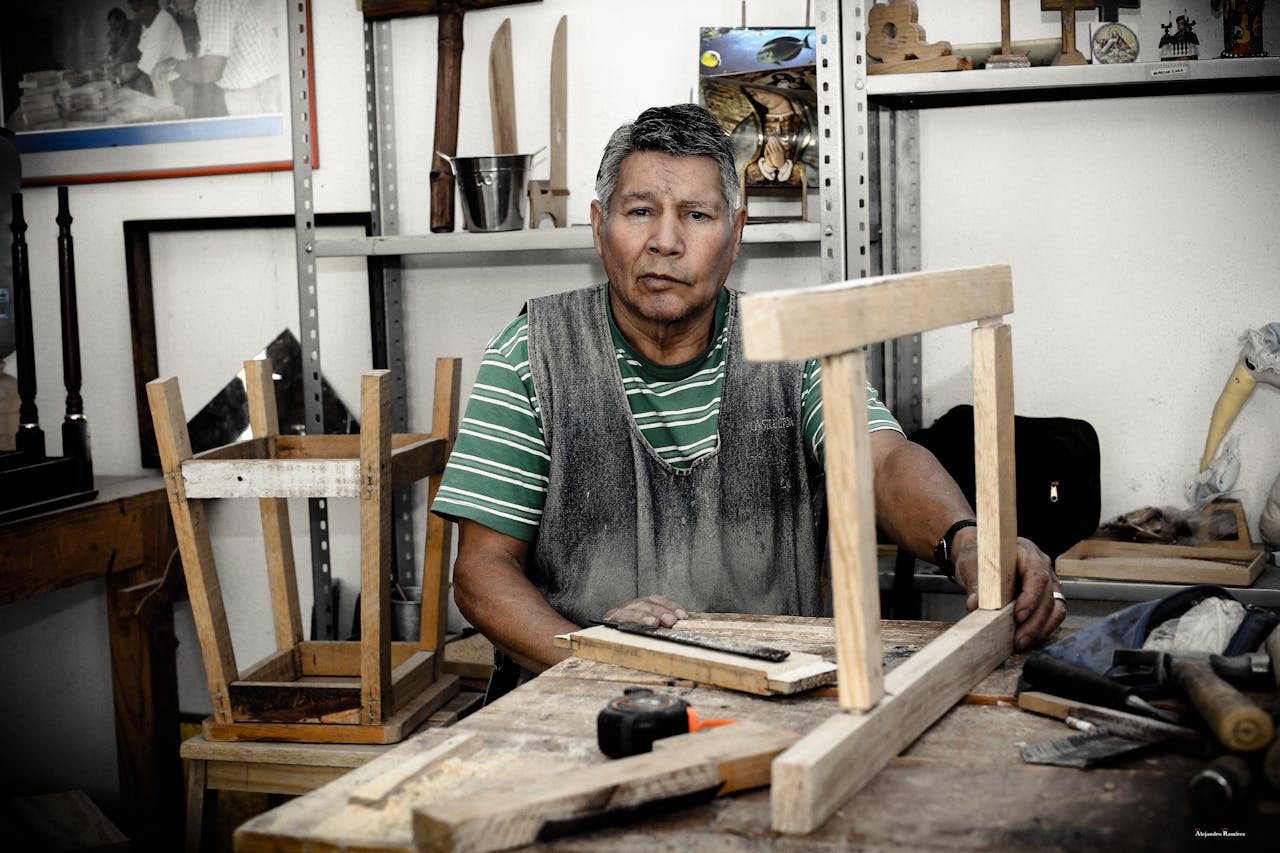 Carpenter Holding Wooden Frame on Table.
