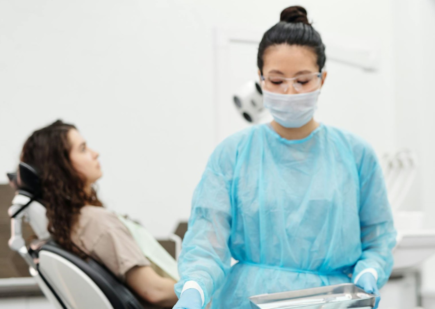 A Woman in Scrub Suit Holding Dental Tools