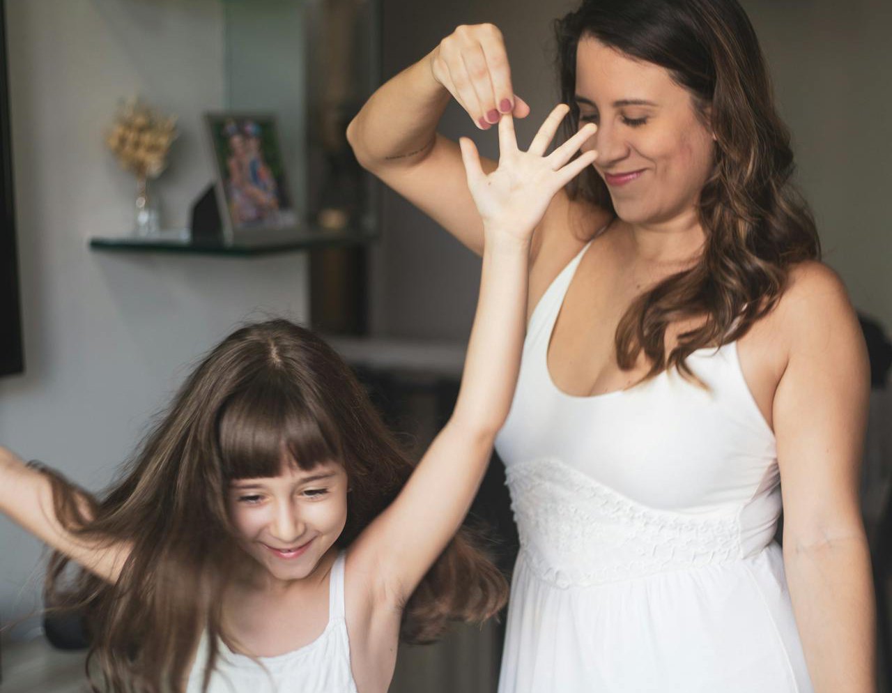 A woman and a little girl in white dresses