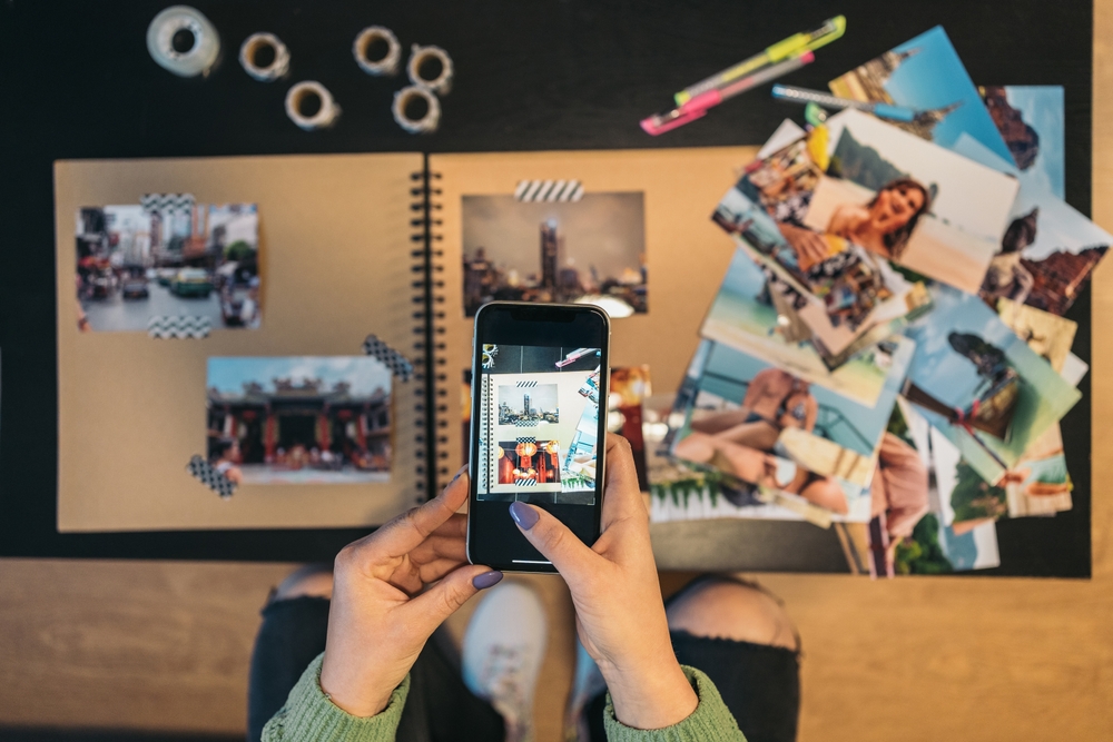 A woman taking a photo of her handmade travel album