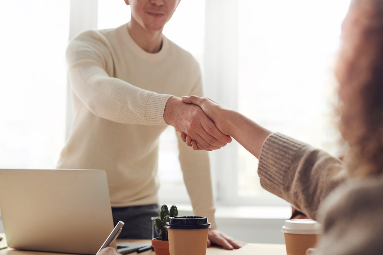 Man and Woman shake Hands Near Table